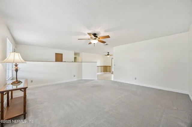 a view of a livingroom with a ceiling fan and window
