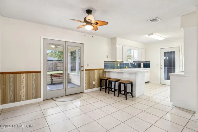 a large kitchen with kitchen island granite countertop a refrigerator a stove a sink and a dining table with wooden floor