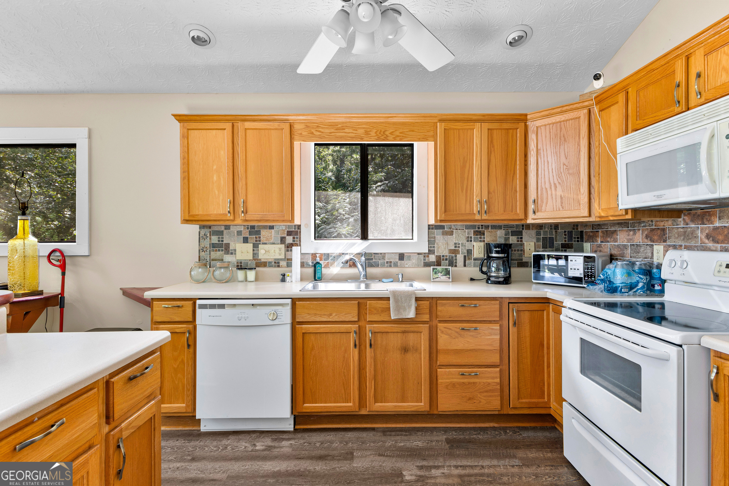 329 Chickadee Court Monticello, GA 31064 - Photo 19 of 59 a kitchen with stainless steel appliances granite countertop a sink a stove cabinets counter space and a window