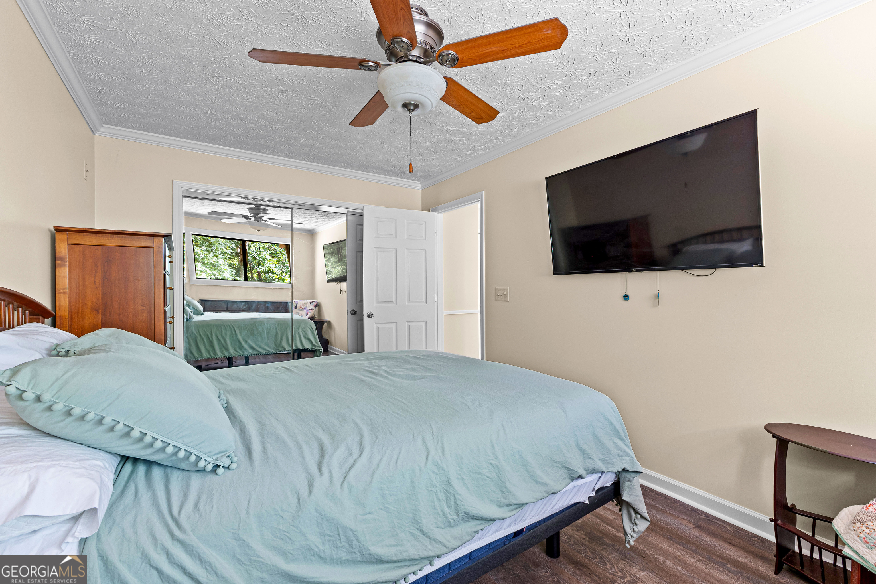 329 Chickadee Court Monticello, GA 31064 - Photo 37 of 59 a bedroom with a bed a flat screen tv and a chandelier