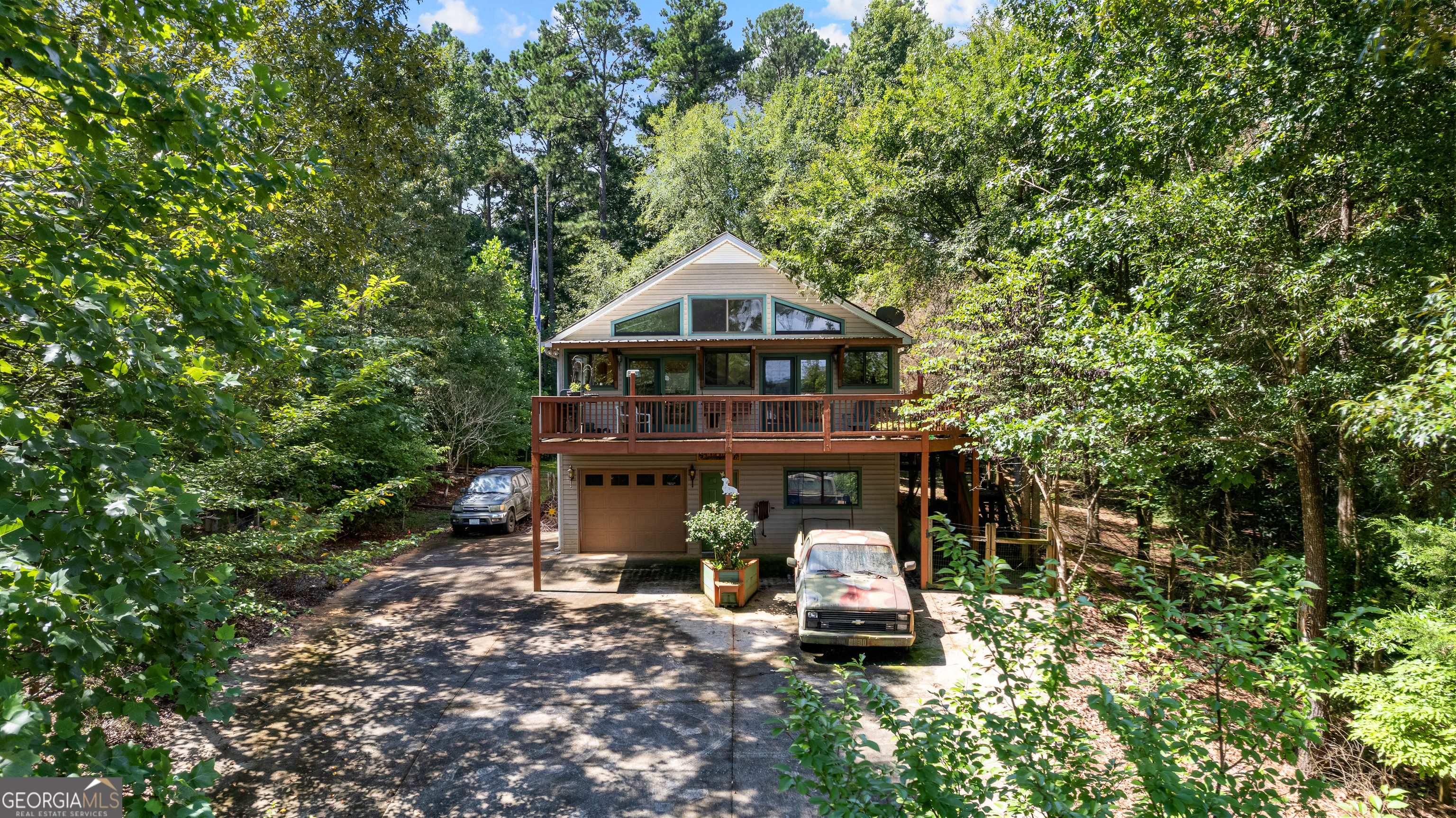 329 Chickadee Court Monticello, GA 31064 - Photo 8 of 59 a view of a tall house with a small yard and large trees