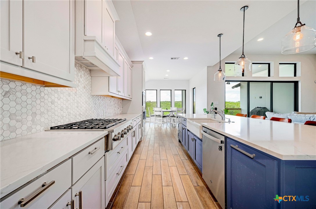 132 Lambs Ear Path San Marcos, TX 78666 - Photo 11 of 43 a large kitchen with stainless steel appliances granite countertop a lot of counter space and a wooden floors