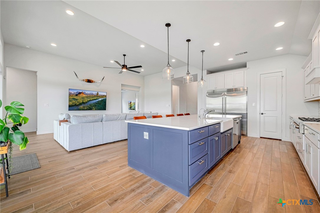 132 Lambs Ear Path San Marcos, TX 78666 - Photo 15 of 43 a large kitchen with stainless steel appliances granite countertop a large counter top and wooden floors