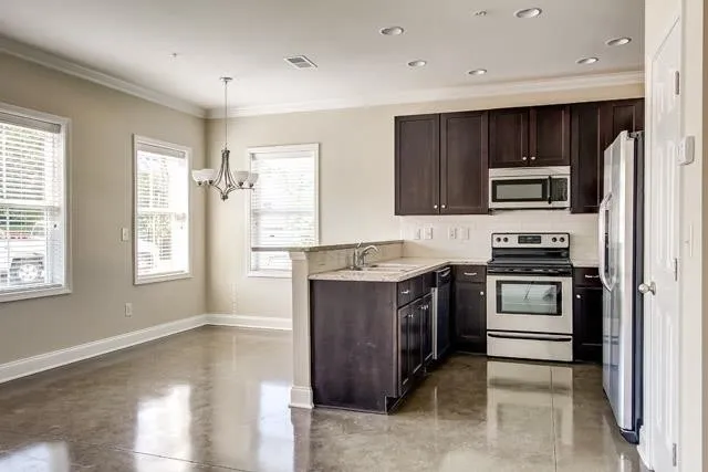 a kitchen with granite countertop a refrigerator and a stove top oven