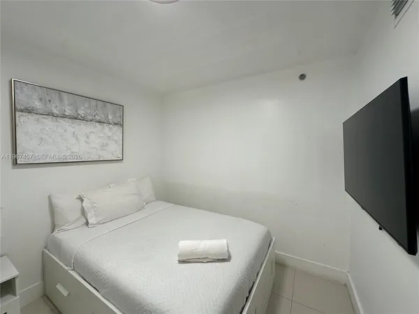 a bedroom with a bed and a flat screen tv