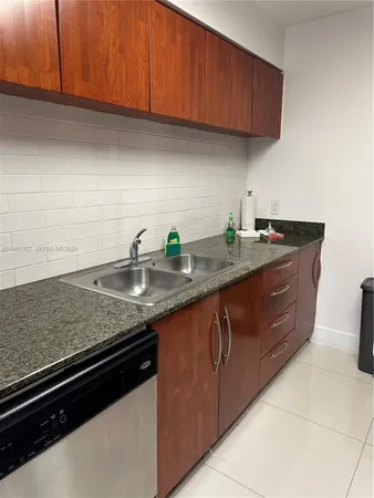 a kitchen with granite countertop stainless steel appliances a sink and cabinets
