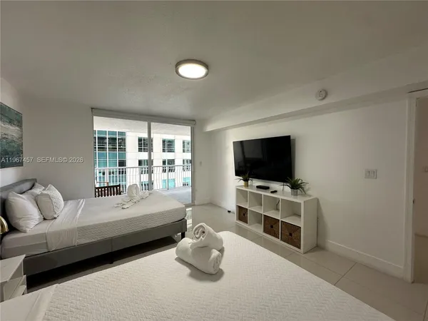 a bedroom with furniture and a flat screen tv