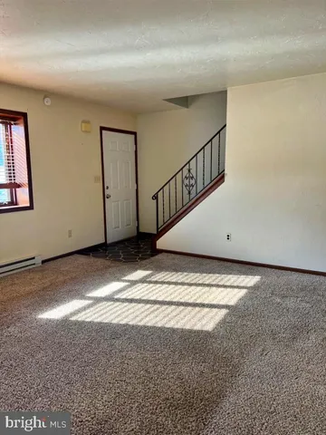 a view of an empty room with wooden stairs