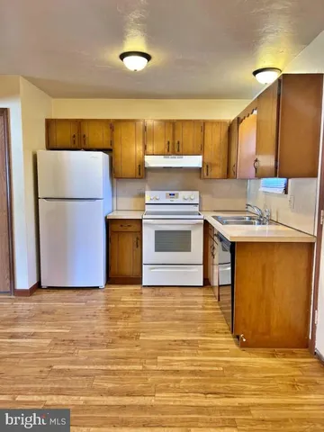 a kitchen with stainless steel appliances granite countertop a sink and a refrigerator