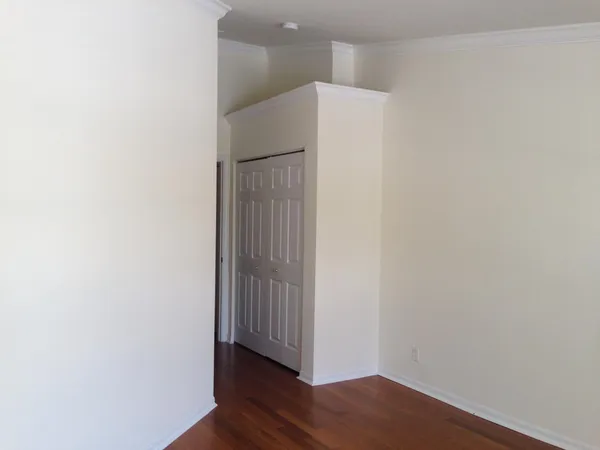 a view of an empty room with wooden floor