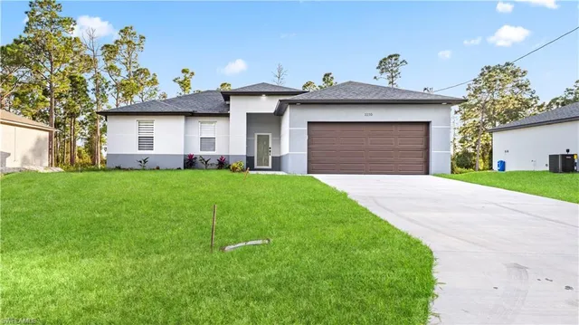 a front view of a house with a garden and plants