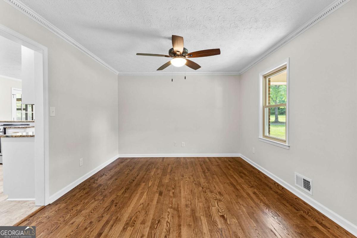550 Davis Road Fayetteville, GA 30215 - Photo 14 of 75 a view of empty room with wooden floor and fan