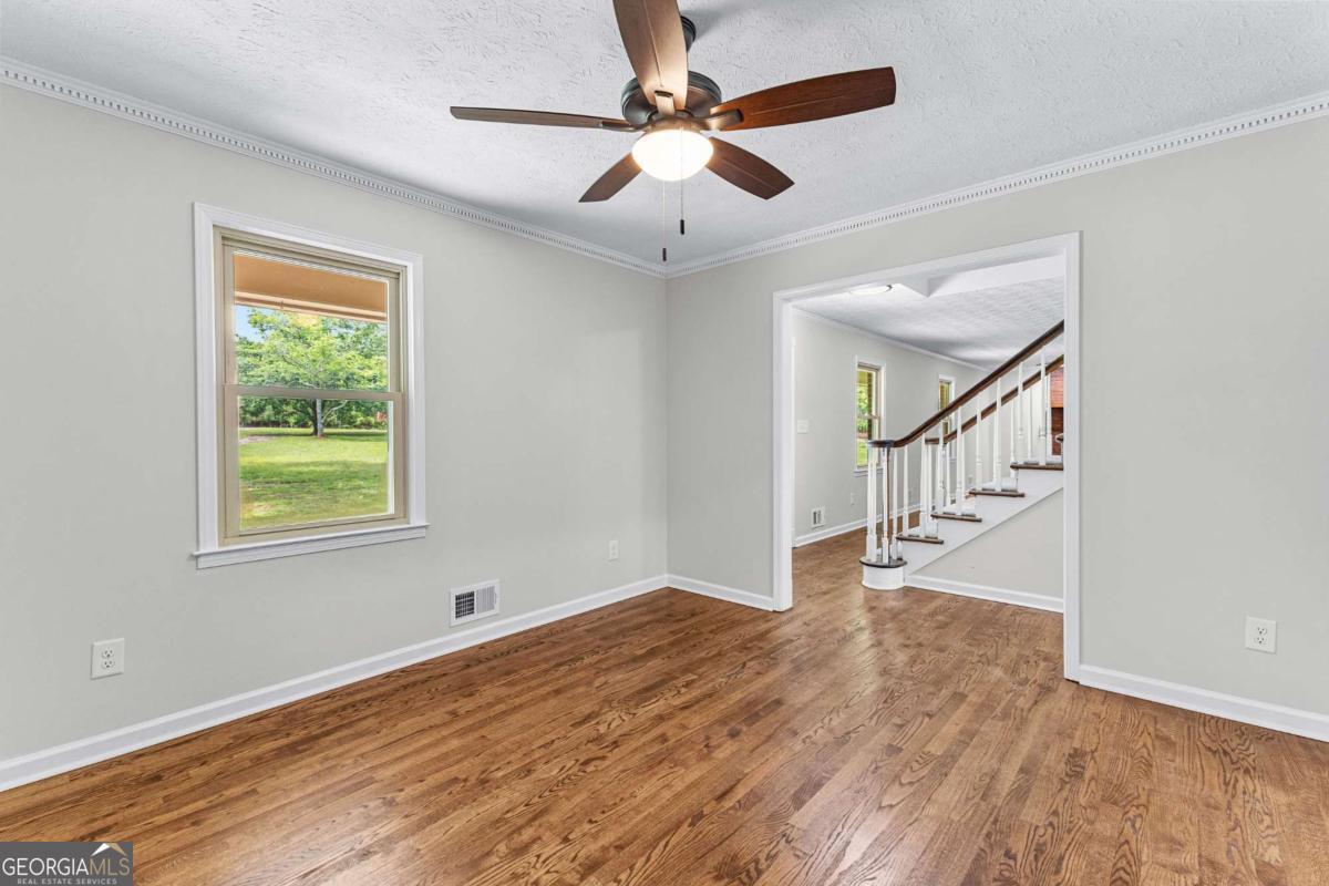 550 Davis Road Fayetteville, GA 30215 - Photo 16 of 75 a view of empty room with wooden floor and fan