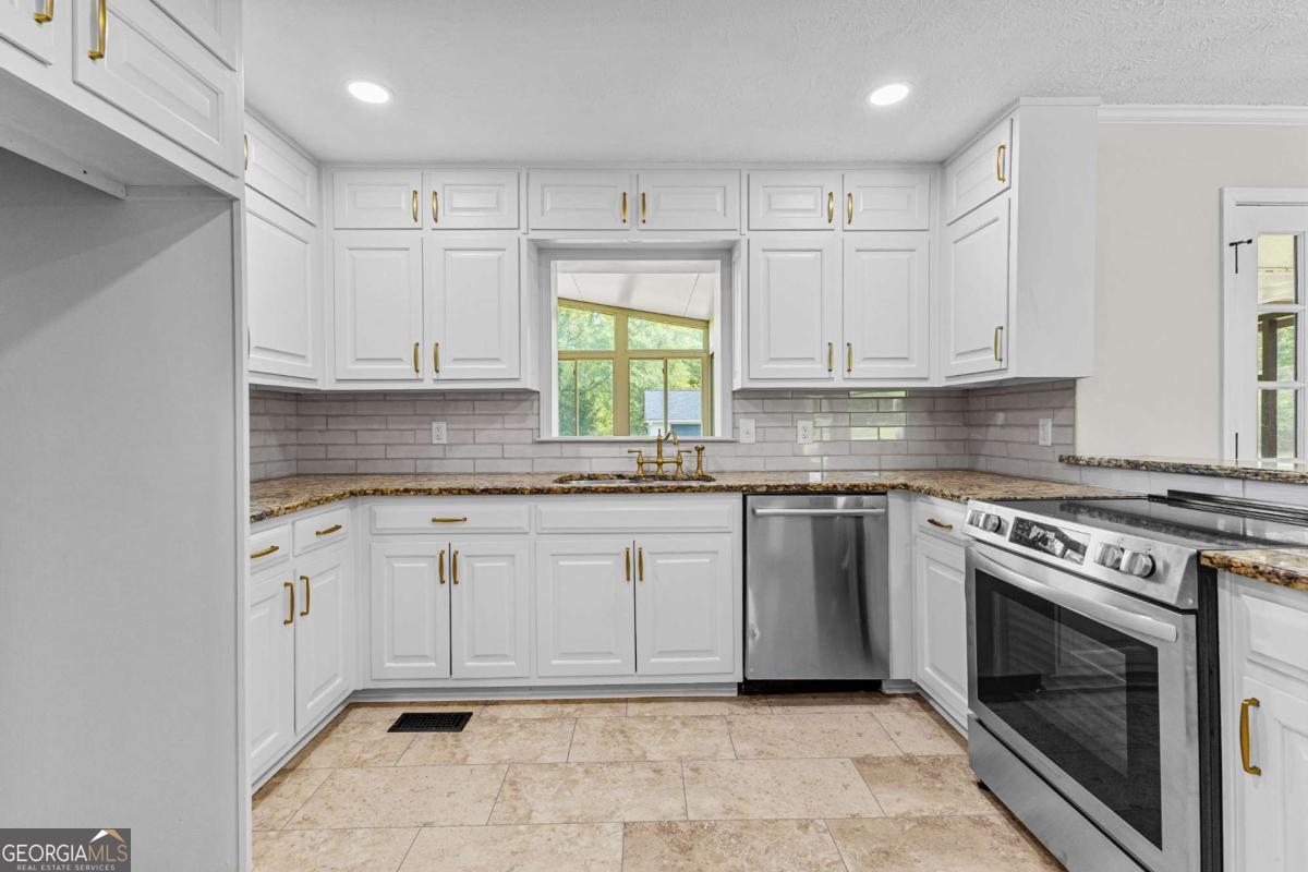 550 Davis Road Fayetteville, GA 30215 - Photo 19 of 75 a kitchen with granite countertop white cabinets stainless steel appliances and a window