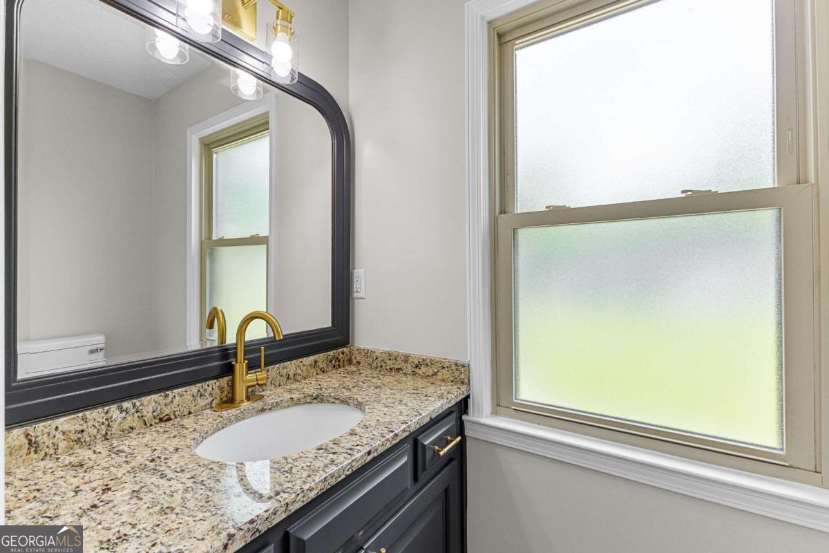 550 Davis Road Fayetteville, GA 30215 - Photo 27 of 75 a bathroom with a granite countertop sink and a mirror