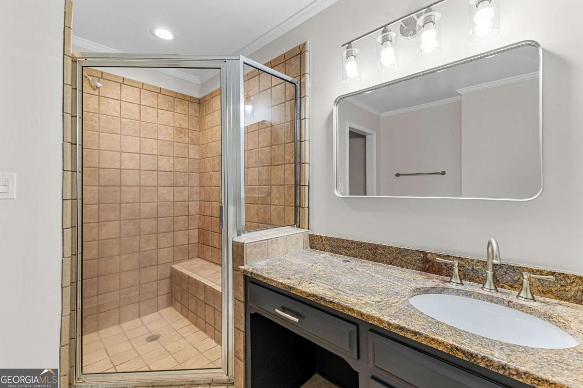 550 Davis Road Fayetteville, GA 30215 - Photo 37 of 75 a bathroom with a granite countertop sink a mirror and shower