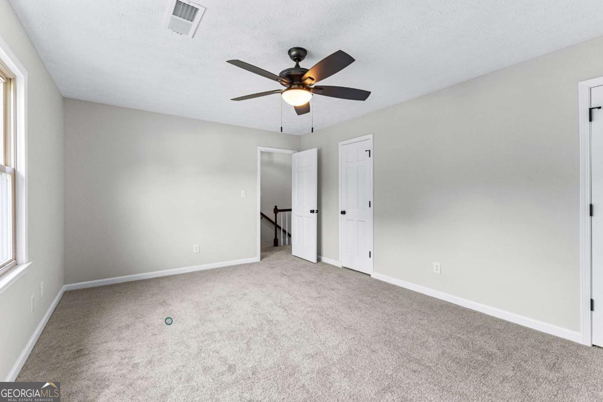 550 Davis Road Fayetteville, GA 30215 - Photo 48 of 75 an empty room with closet and a chandelier fan