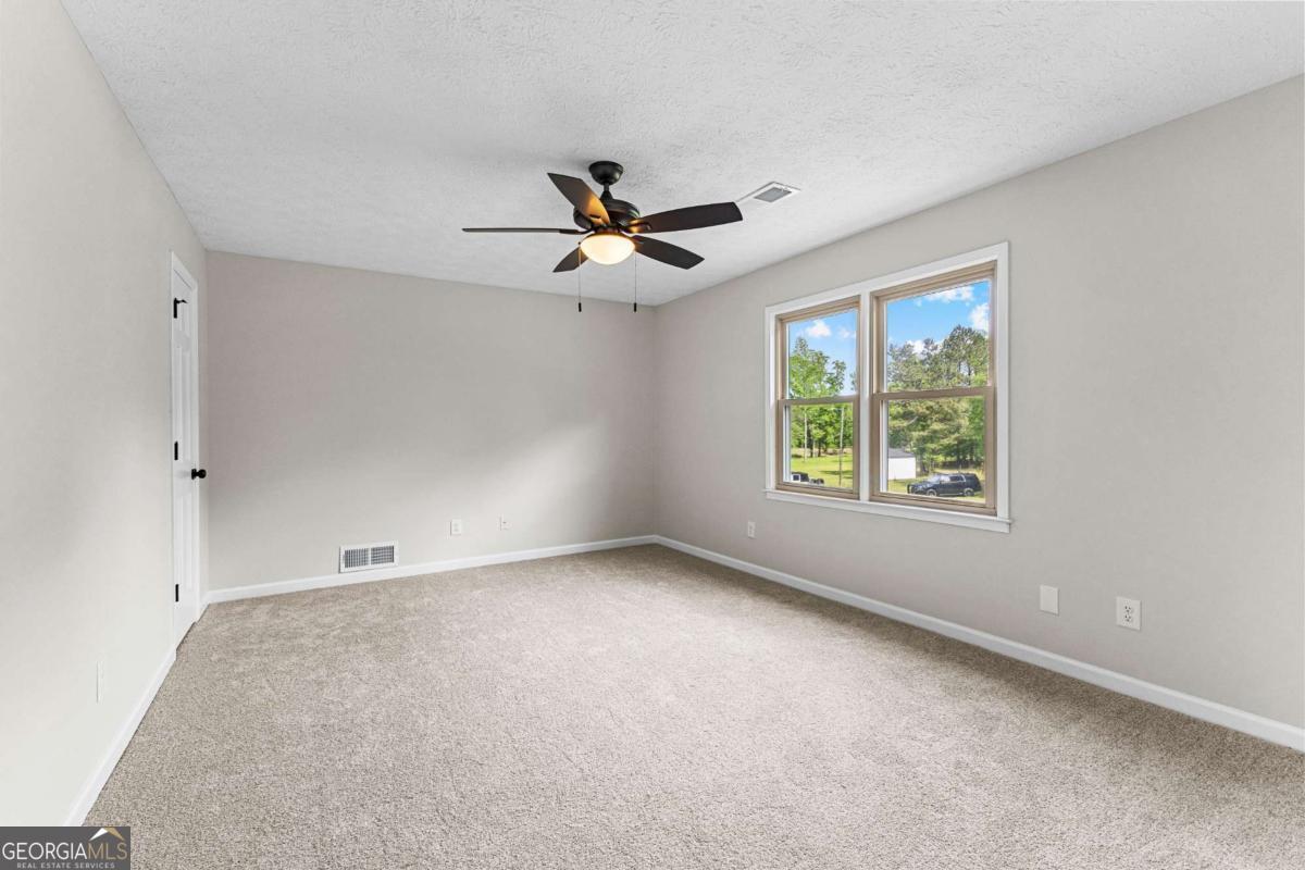 550 Davis Road Fayetteville, GA 30215 - Photo 49 of 75 an empty room with windows and ceiling fan