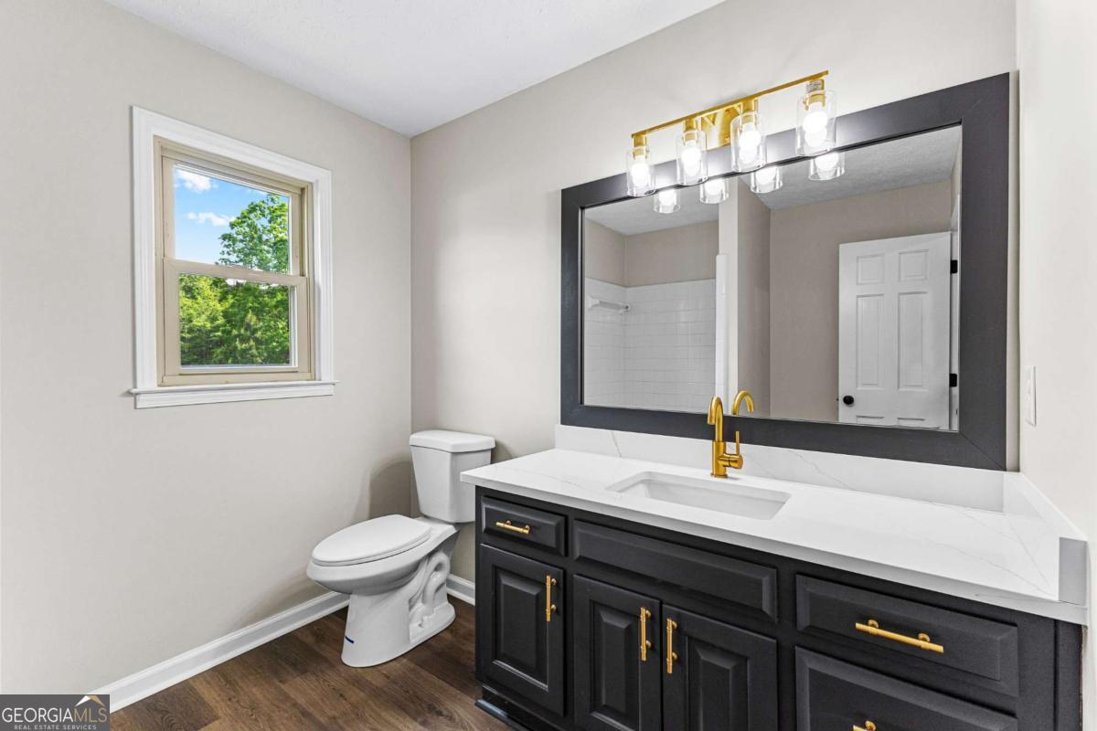 550 Davis Road Fayetteville, GA 30215 - Photo 51 of 75 a bathroom with a sink a toilet and a mirror