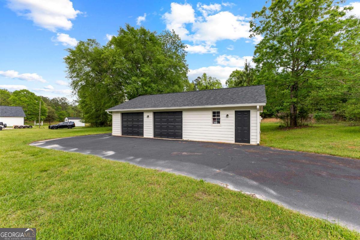 550 Davis Road Fayetteville, GA 30215 - Photo 65 of 75 a view of a house with backyard and a tree