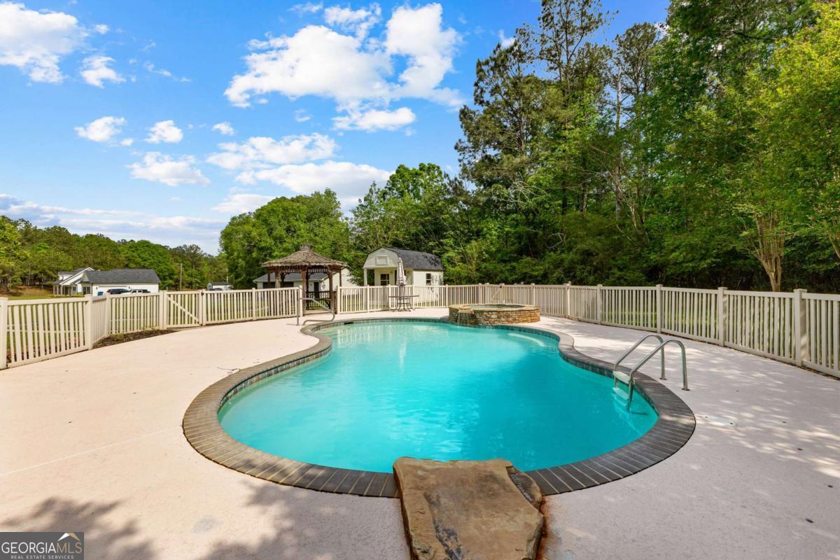 550 Davis Road Fayetteville, GA 30215 - Photo 68 of 75 a view of a swimming pool with a bench and trees in the background