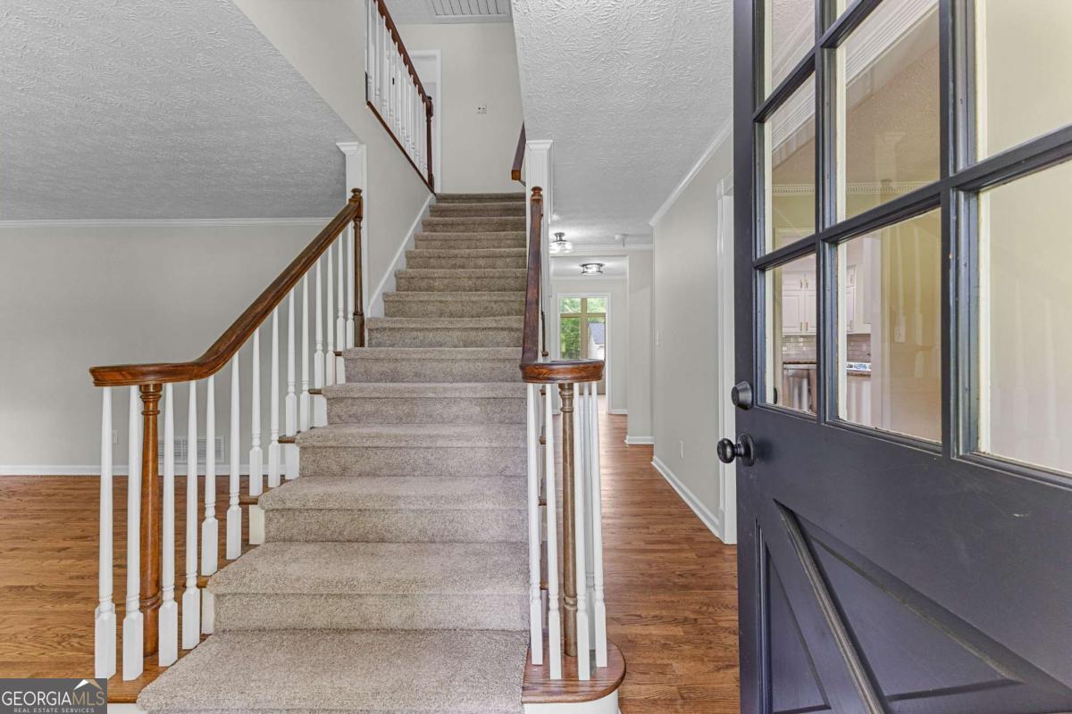 550 Davis Road Fayetteville, GA 30215 - Photo 10 of 75 a view of staircase with lots of frames on wall and windows
