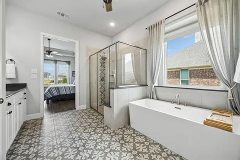 a en suite spacious bathroom with a tub shower and a window