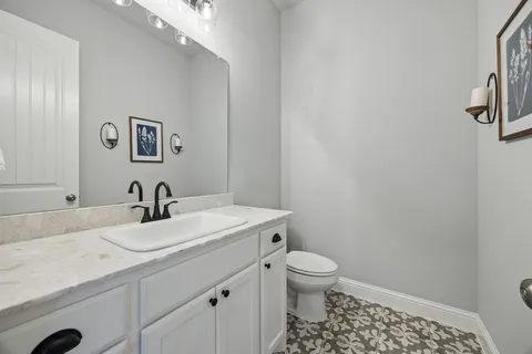 a bathroom with a sink a toilet and a mirror