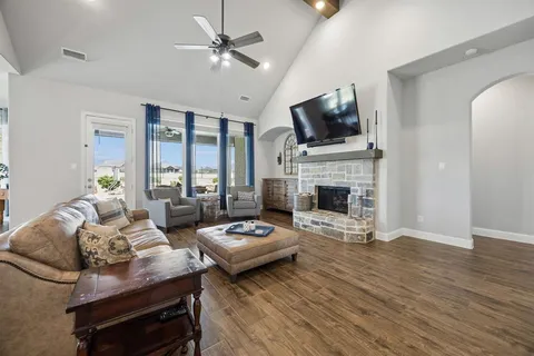 a living room with furniture a flat screen tv and a fireplace