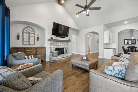 a living room with furniture a fireplace and a flat screen tv