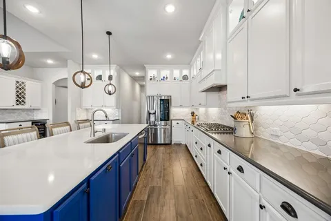 a large kitchen with stainless steel appliances lots of counter space and wooden floor