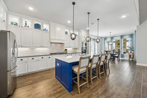 a large kitchen with lots of counter space dining table and stainless steel appliances