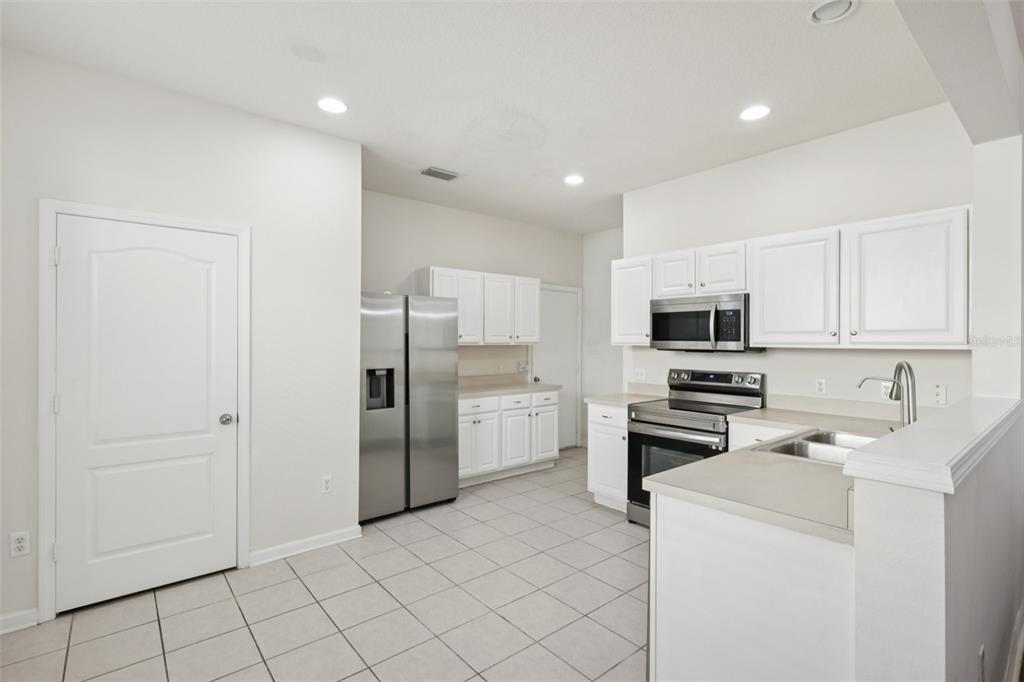 5001 Barnstead Drive Riverview, FL 33578 - Photo 11 of 37 a kitchen with stainless steel appliances a refrigerator stove and white cabinets