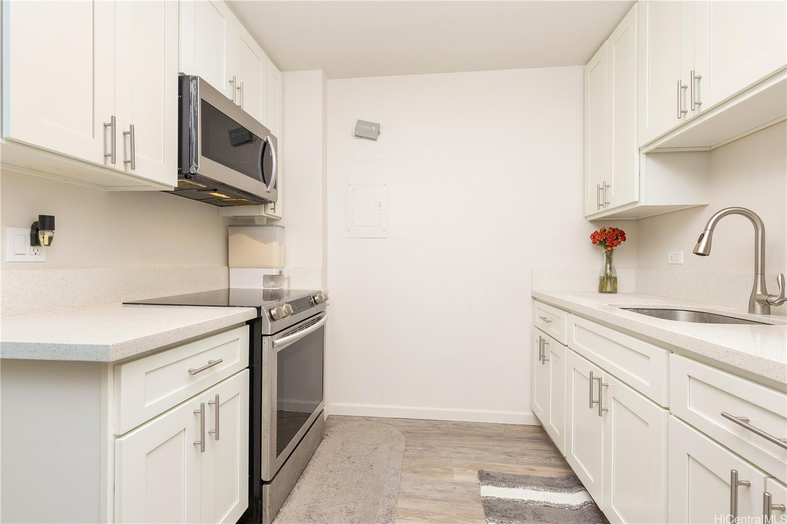 98-1032 Moanalua Road, Unit 3103 Aiea, HI 96701 - Photo 4 of 10 a kitchen with stainless steel appliances granite countertop white cabinets and window