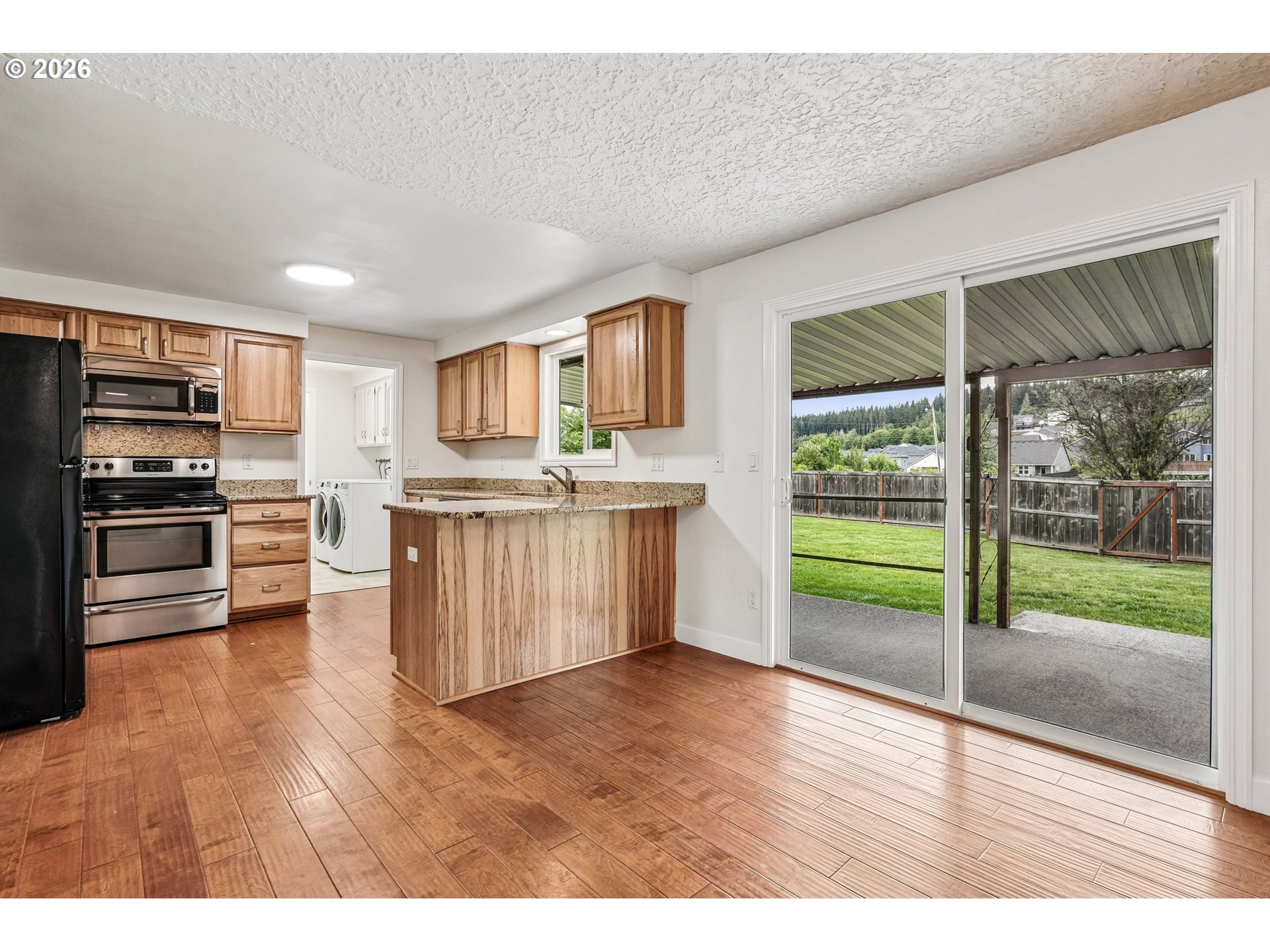 22600 Northeast 28th Street Camas, WA 98607 - Photo 12 of 48 a kitchen with stainless steel appliances granite countertop a refrigerator a stove top oven and a large window