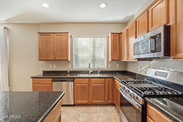 a kitchen with granite countertop a sink stove and cabinets