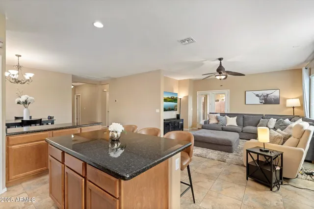 a kitchen with a counter space a sink and living room view