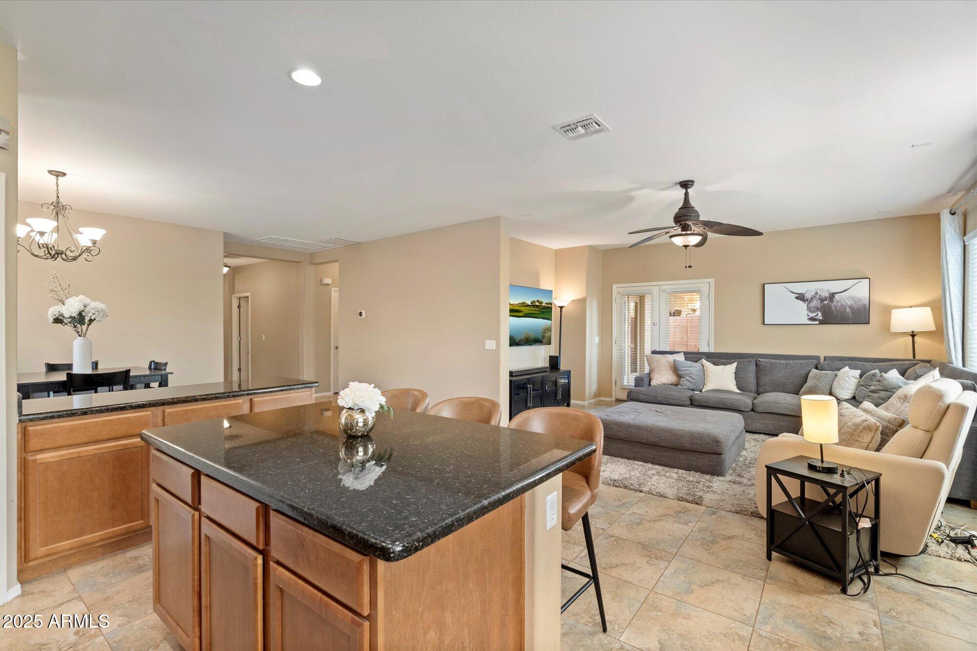 6710 South Seton Avenue Gilbert, AZ 85298 - Photo 16 of 51 a kitchen with a counter space a sink and living room view