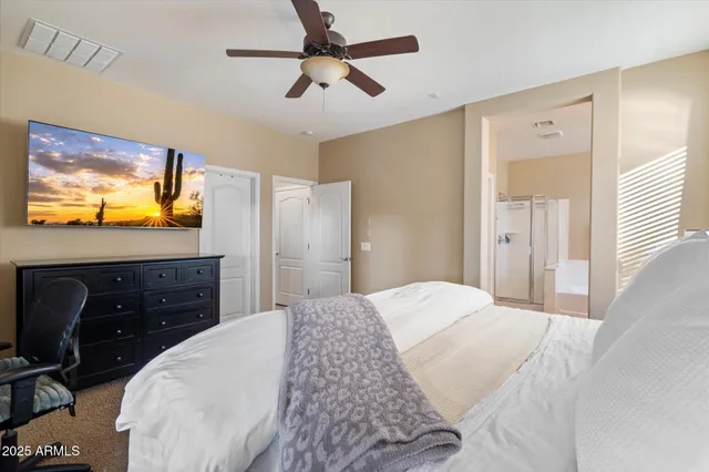 a bedroom with a bed and a flat tv screen on dresser