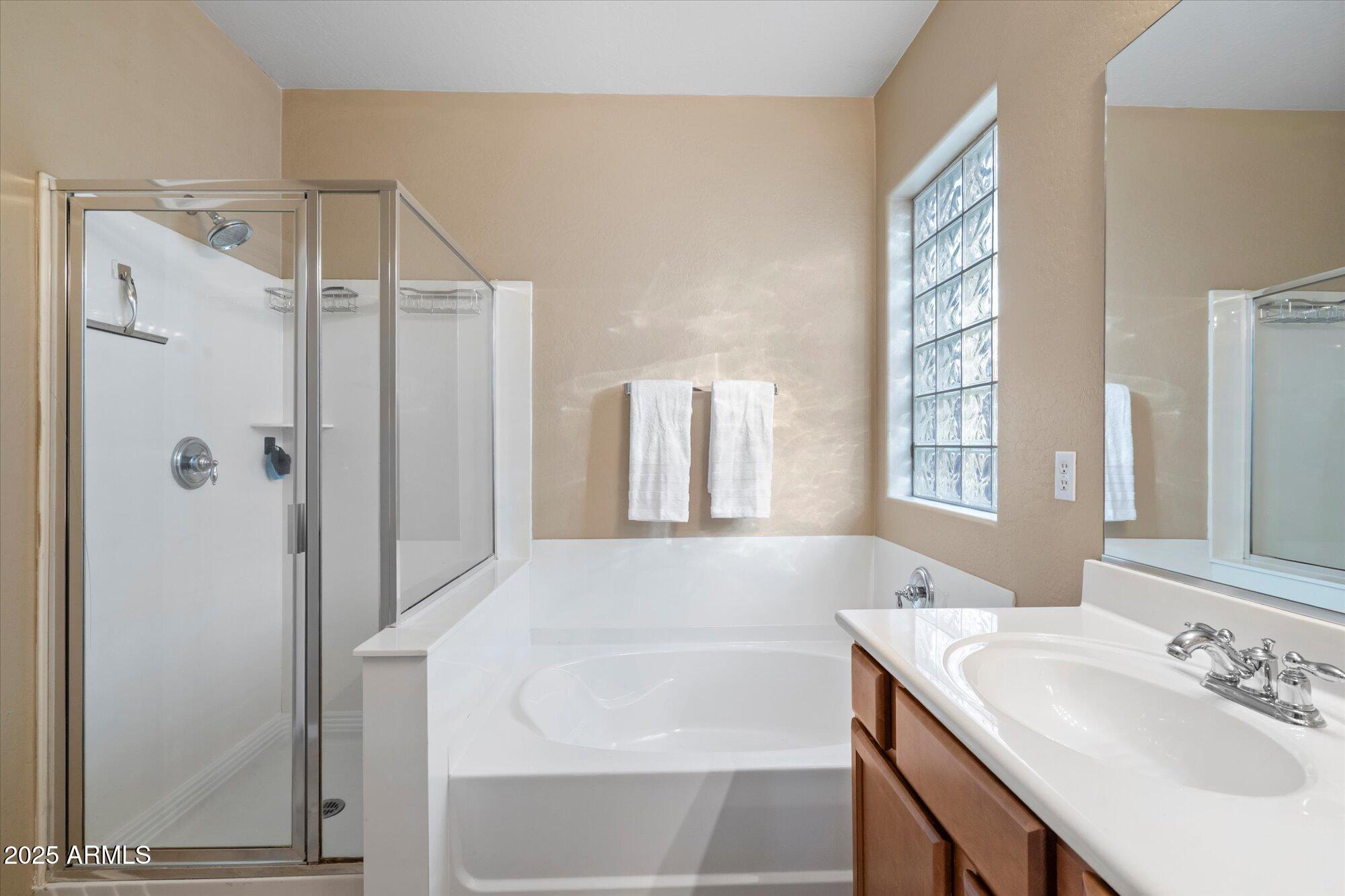 6710 South Seton Avenue Gilbert, AZ 85298 - Photo 27 of 51 a bathroom with a bathtub a sink a vanity and a shower