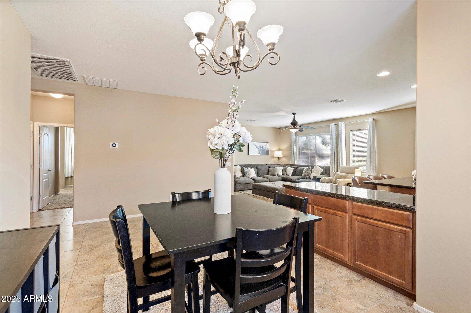 6710 South Seton Avenue Gilbert, AZ 85298 - Photo 10 of 51 a dining room filled chandelier and kitchen view