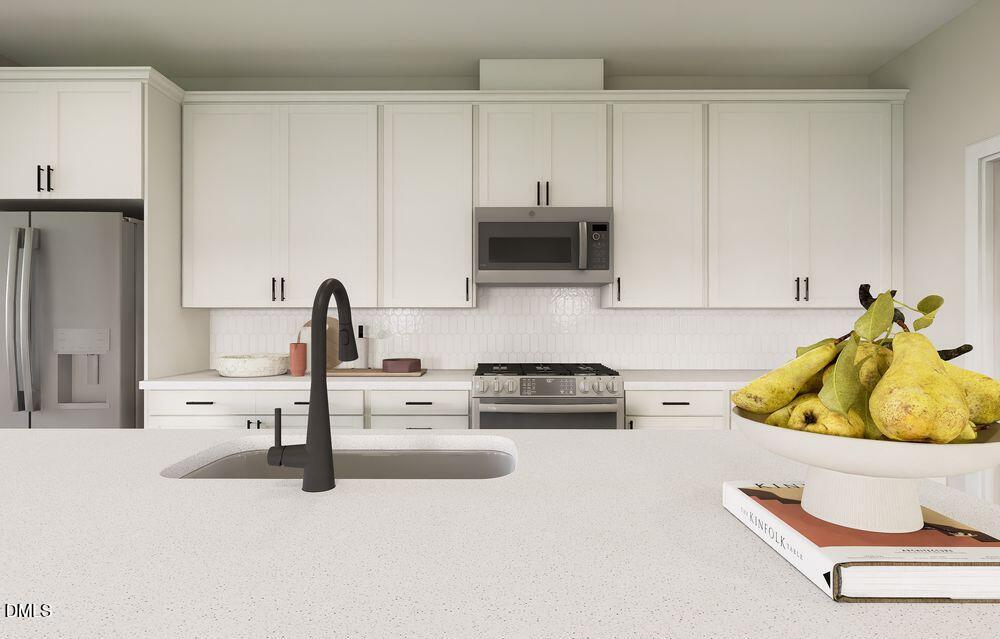 740 Bolera Road Knightdale, NC 27545 - Photo 11 of 32 a kitchen with stainless steel appliances kitchen island granite countertop a sink a stove and a refrigerator