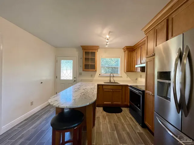 a kitchen with a table chairs refrigerator and microwave
