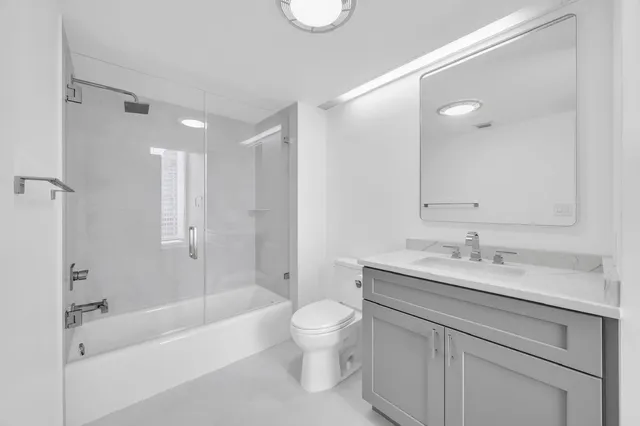 a bathroom with a granite countertop sink a toilet and bathtub