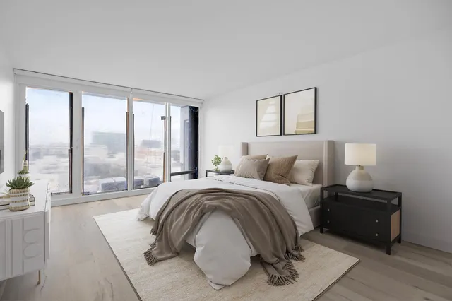 a spacious bedroom with a bed and glass walk in closet