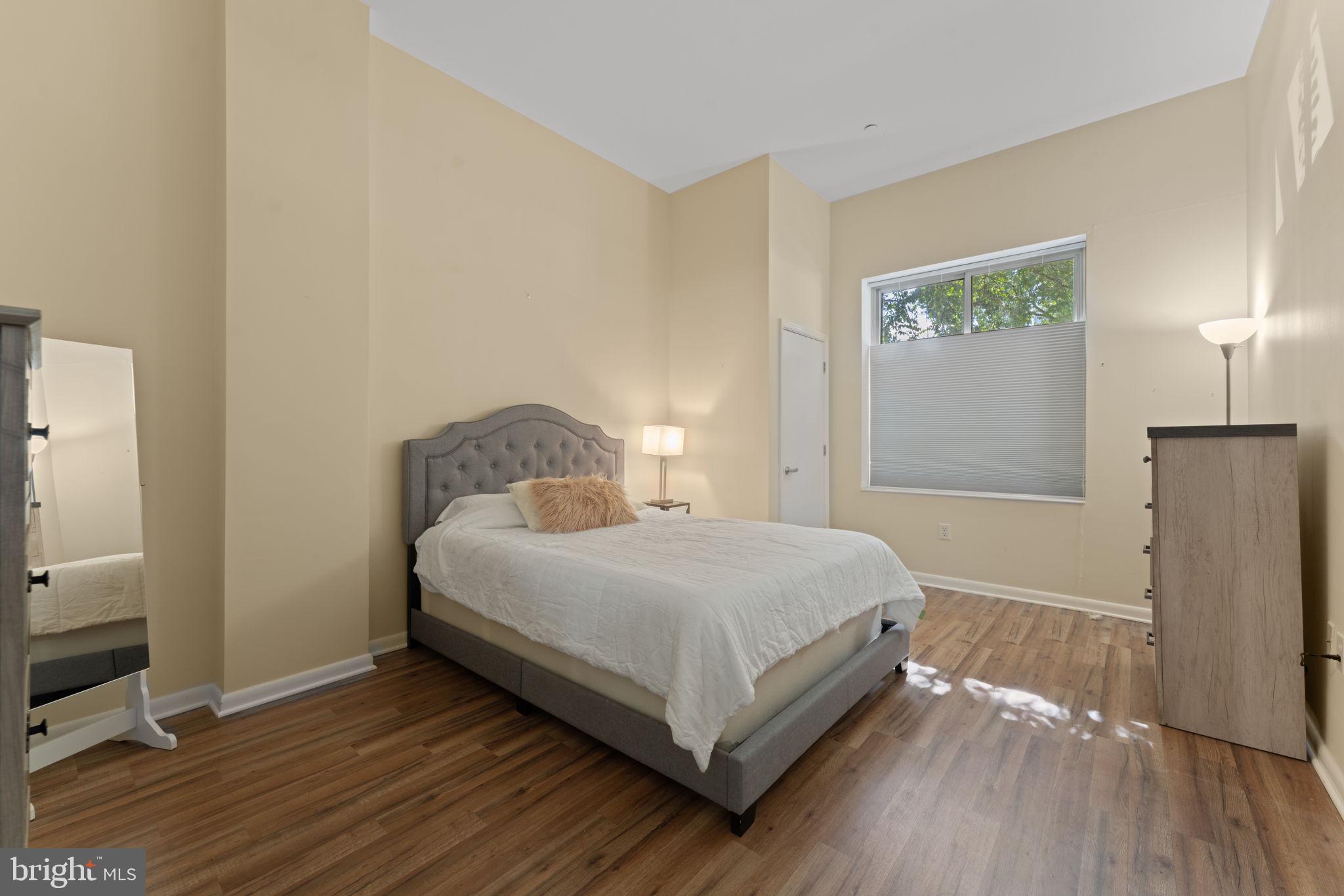 355 I Street Southwest, Unit S104 Washington, DC 20024 - Photo 16 of 64 a bedroom with a bed and wooden floor