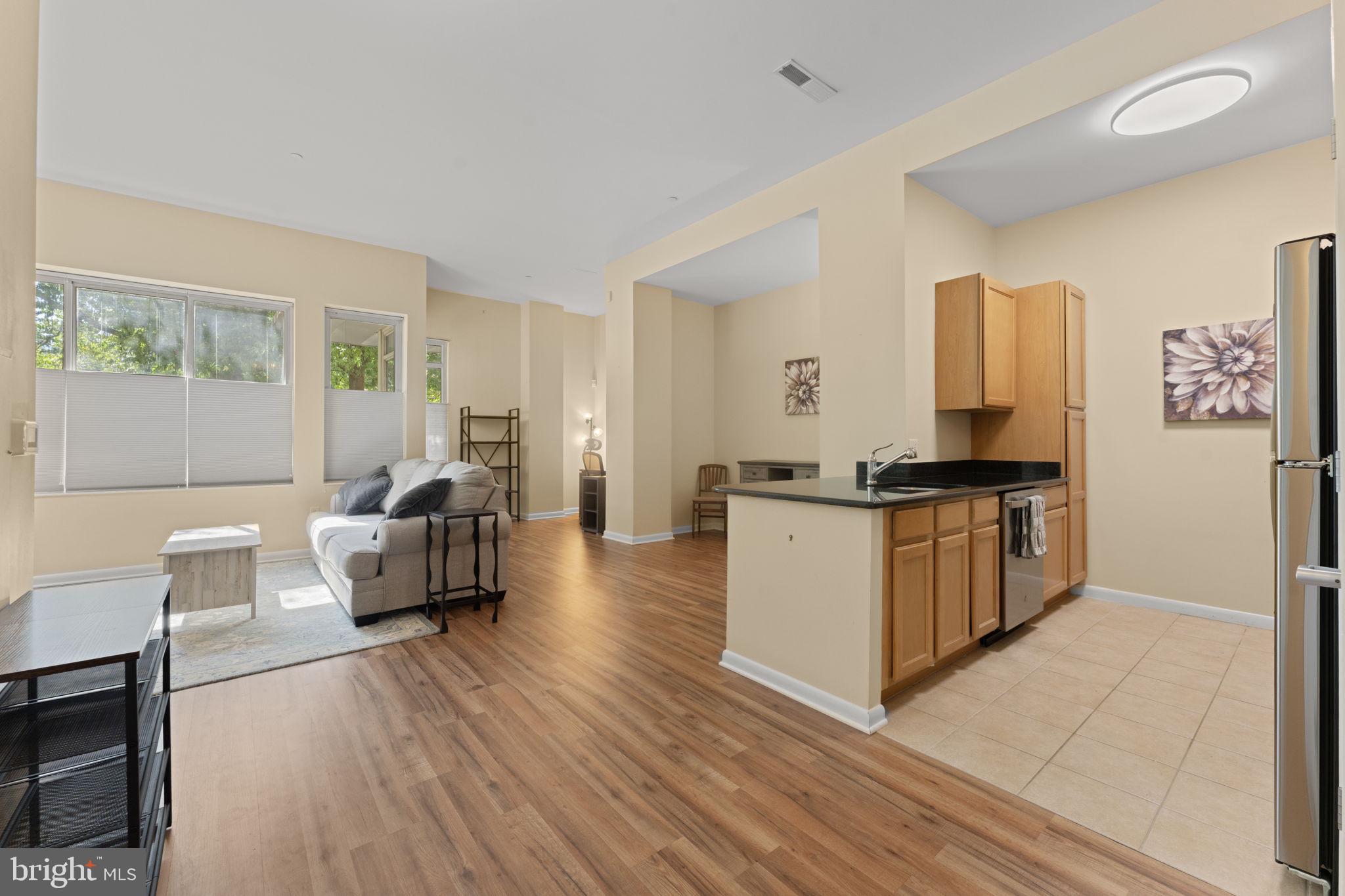 355 I Street Southwest, Unit S104 Washington, DC 20024 - Photo 3 of 64 a living room with furniture and wooden floor