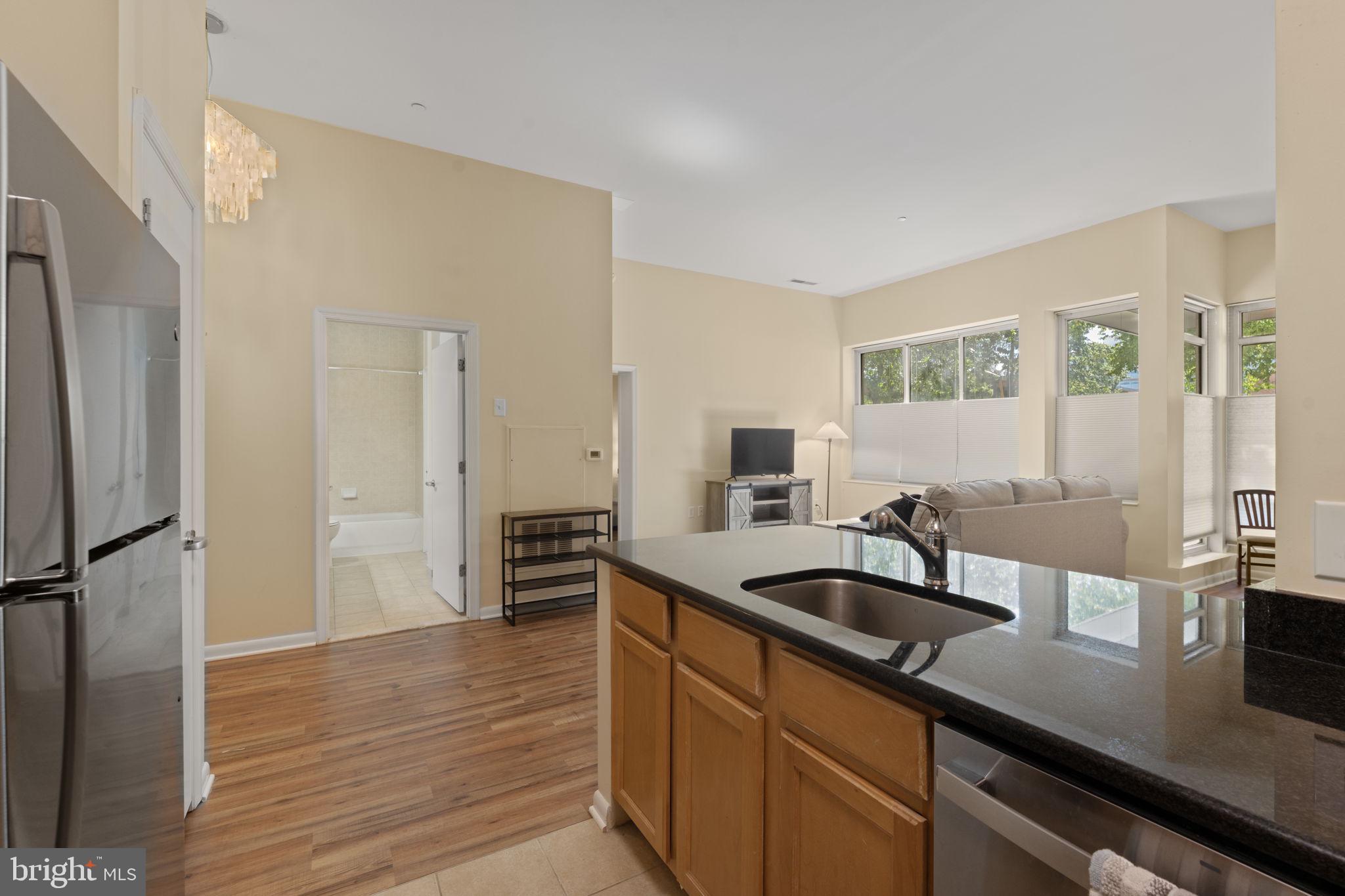 355 I Street Southwest, Unit S104 Washington, DC 20024 - Photo 8 of 64 a kitchen with stainless steel appliances granite countertop a sink and a refrigerator
