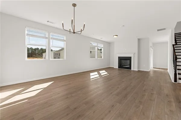 a view of empty room with wooden floor and fireplace