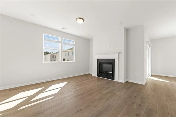 an empty room with windows and a fireplace